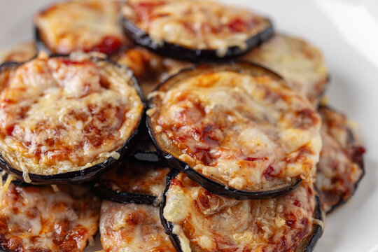 Eggplant with parmesan and tomato sauce in plate on the table