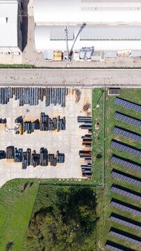 Aerial view of Lobo S.p.A. industrial facility featuring outdoor storage of metal coils and rows of solar panels on the adjacent grounds in Cornaredo, Lombardia, Italy.