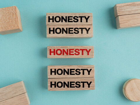 Wooden blocks displaying the word HONESTY arranged on a light blue background, suitable for presentations.