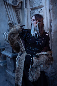 Fantasy warrior woman in leather armor with feather pauldron and fur, cosplay and role play.