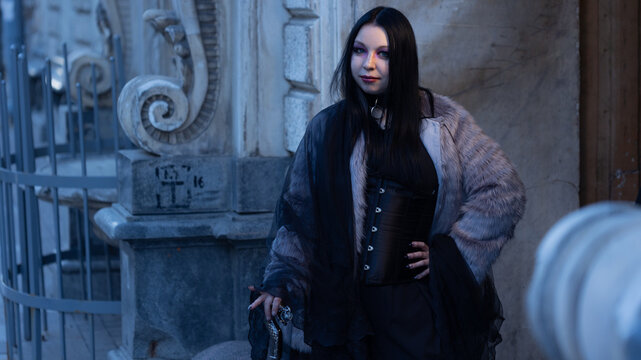 Confident woman in leather corset and fur coat posing at old facade, self acceptance concept.