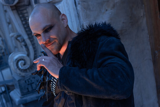 Man with sly smile touching his face, cunning villain character, dark alternative style.