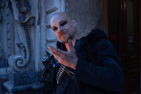 Dark magician making a hand gesture, spell and magic concept in gothic male style.