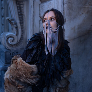 Fantasy warrior character in a chain veil and black feather armor, cosplay costume portrait