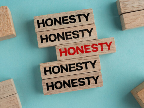 Wooden blocks displaying the word HONESTY arranged on a light blue background, suitable for presentations.