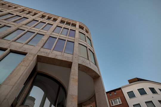 Hanover, Germany - July 1, 2026: Low-angle architectural view of a modern stone-clad office building beneath blue sky in Hanover city centre.