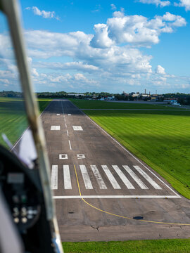 Aerial view of S. Darius and S. Girenas Aerodrome runway with green grass fields and blue sky in Kaunas, Kaunas County, Lithuania.