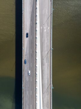 Aerial view of the Ponte Rainha Santa Isabel bridge spanning the Mondego River with cars driving on the asphalt road in Coimbra, Coimbra, Portugal.