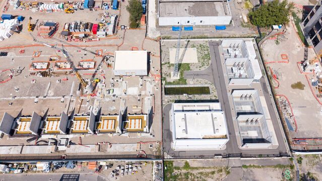 Aerial view of the Equinix MLSS1 data center construction site with concrete foundations, industrial infrastructure, and heavy machinery in Castelletto, Lombardia, Italy.