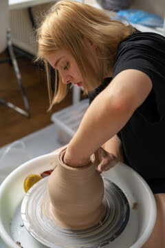 The girl sculpts a vase from clay. Lifestyle