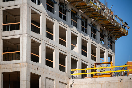 Concrete residential building under construction. Modern apartment development site.