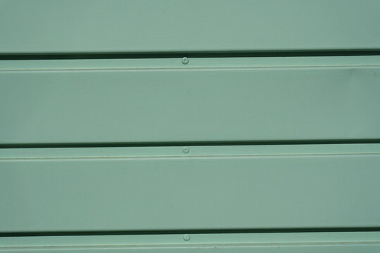 Green horizontal metal cladding panels with rivets