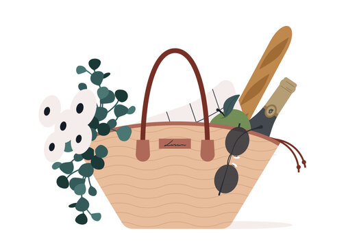 A charming picnic basket sits filled with a fresh baguette, sparkling drink, sunglasses, and flowers, ready for a joyful afternoon in the sunshine at a beautiful park.