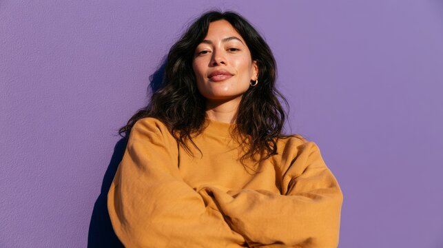 Young Woman in Casual Clothing, Sitting Against Colorful Wall, Leaning on Arm, Looking Off to Side.