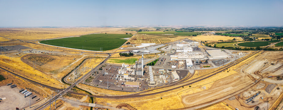 Aerial view of a data center facility and power plant surrounded by agricultural fields and dry landscape in Umatilla, Oregon, United States.