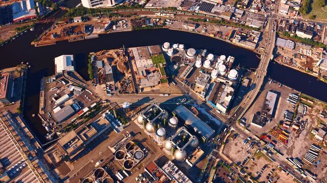 Rising over Newtown Creek Wastewater Treatment Plant with famous silver egg-shaped sludge digester tanks. Sunlit industrial area of Brooklyn/Queens, New York City, USA.