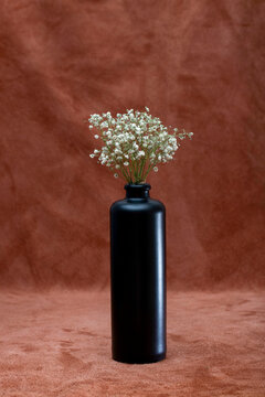 A small bouquet of flowers in a tall black bottle