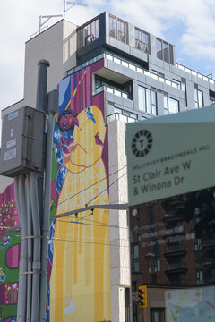 defocused control box, TO360 post, and distant view of Yellow Oasis from STEPS Public Art, by Artist Yasaman Mehrsa, at 840 St Clair Av W and TD bank branch at 870 St Clair Av W, Toronto