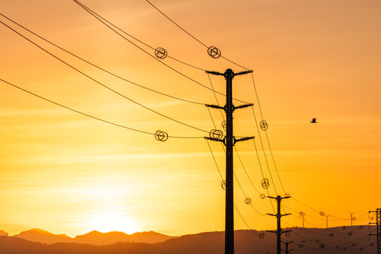 Electrical transmission infrastructure and utility cables against vibrant sunset sky highlighting reliable energy distribution 