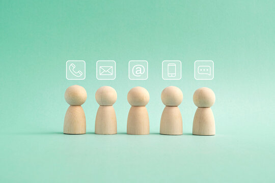 Wooden blocks on table showing phone, email, address and live chat icons. Contact us about customer service center connectivity concept. Internet communication via website