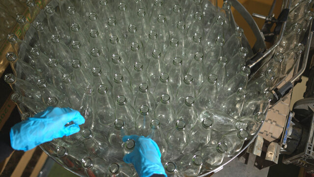 Bottles for fruit juice are on a conveyor belt and being transported into the factory's automatic filling process