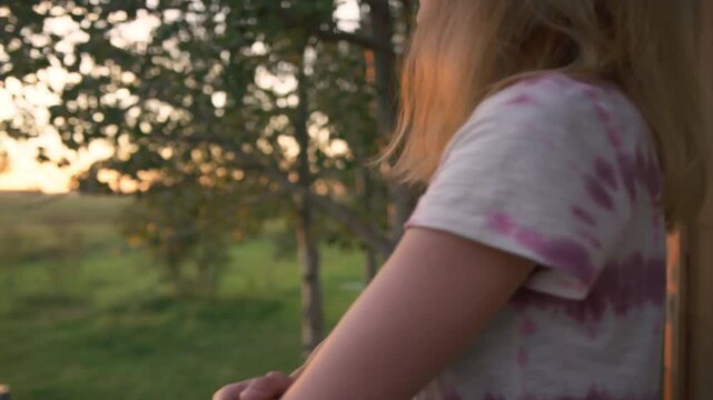 Close-up of woman's hair catching the breeze at golden hour in garden