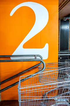  Abstract Close-Up of a Number 2 Painted on an Orange Background With Shopping Trolleys in the Foreground