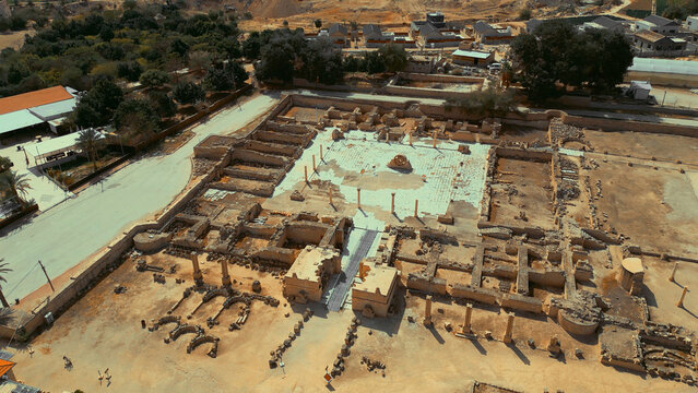 View of Hisham's Palace, an ancient Umayyad Islamic site featuring intricate stone ruins, columns, and mosaic floors in the desert landscape of Jericho, West Bank, Palestine.