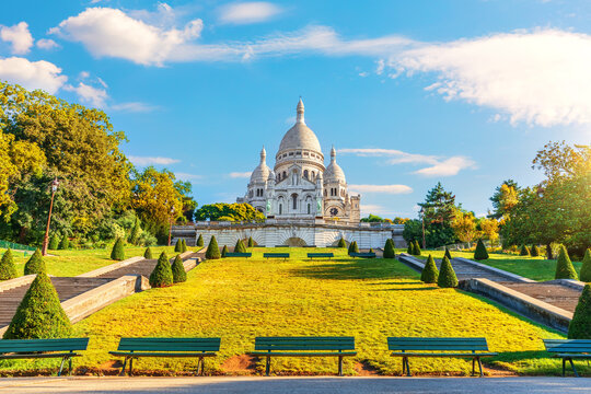 Sacred Heart Basilica in Montmartre view from garden steps under dramatic cloudy sky, Paris, France