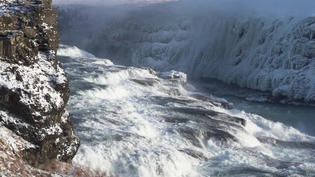 アイスランドの冬、凍りついた岩壁と流れ落ちる巨大な滝の激流（Iceland Winter Waterfall）