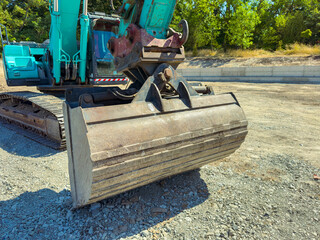 Heavy machinery with a large scoop attachment working on a construction site during daylight hours © DSMT