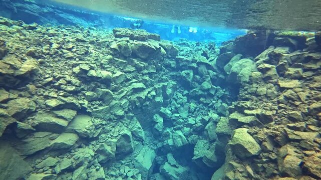 アイスランドの透明な地殻の裂け目を潜る水中映像、溶岩岩の谷とシュノーケラー（Iceland Underwater Rift Snorkeling Clear Water）