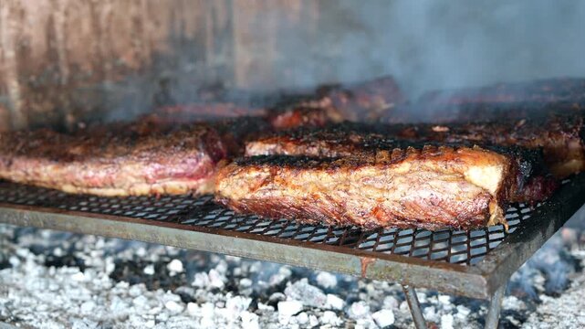 Argentine rib eye and bife de chorizo grilling over wood embers on parrilla &mdash; 4K