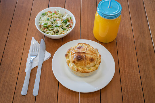 Brazilian empada meal with salad and orange juice