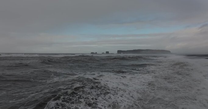アイスランド南部の荒れた海と黒砂海岸、遠くに岬と海食柱（Iceland Black Sand Beach Rough Waves and Sea Stacks）