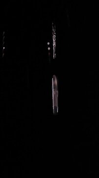 Vertical video. Clear Water Streams Fall Against a Black Background, Creating a Dramatic Abstract Liquid Texture and Freshness
