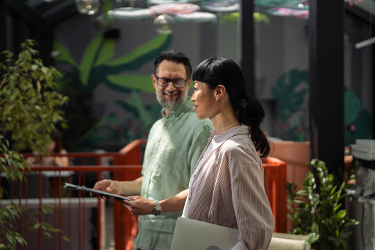Diverse business professionals collaborating outdoors in informal office setting