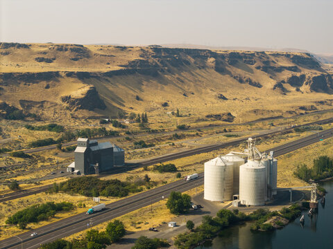 Aerial view of grain silos situated near a highway and the Columbia River in the Columbia River Gorge National Scenic Area, Oregon, United States.