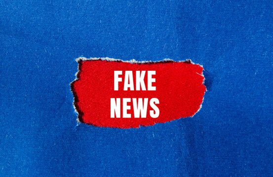 Fake news message written on ripped torn paper background. Conceptual Fake news symbol. Copy space.