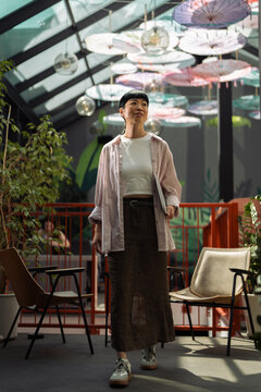 Asian woman walking with laptop looking inspired