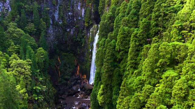 Secluded Waterfall Nestled In A Steep Lush Valley At Cascata das Lombadas On S&atilde;o Miguel Island In The Azores, Portugal. Aerial Approaching Shot