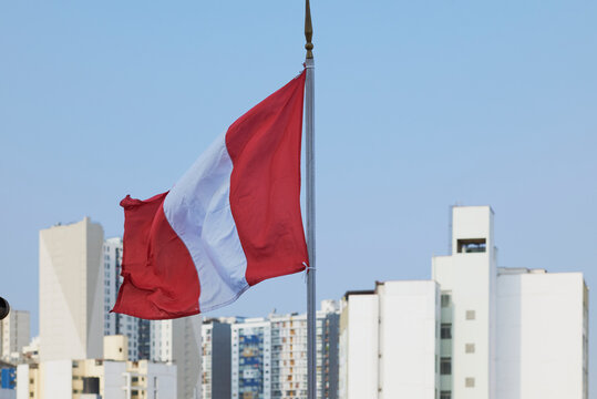 Peruvian flag waving high over lima cityscape
