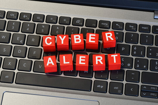 Cyber Alert text on red cubes on laptop keyboard, cybersecurity warning and data breach prevention concept