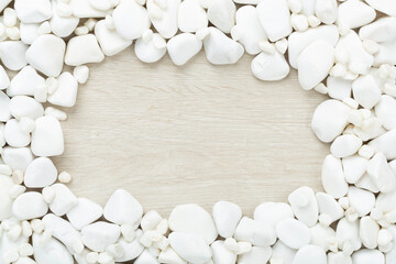 White pebble stones on wooden background, top view © Liami