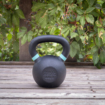heavy iron competition kettlebell for weight training on wooden grunge deck, home gym and fitness concept