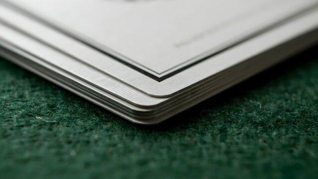 Close-up of paper documents with rounded edges on textured surface
