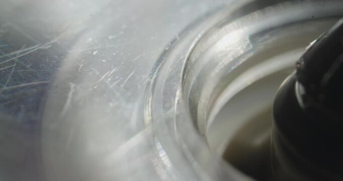 Extreme macro captures a cassette tape spool spinning rapidly during fast forward inside a vintage recording machine, highlighting analog mechanical operation.
