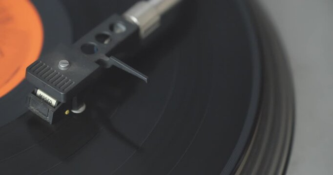 Top-down close-up shows a stylus playing a vinyl LP before the tonearm automatically returns at the end, demonstrating retro analogue technology.