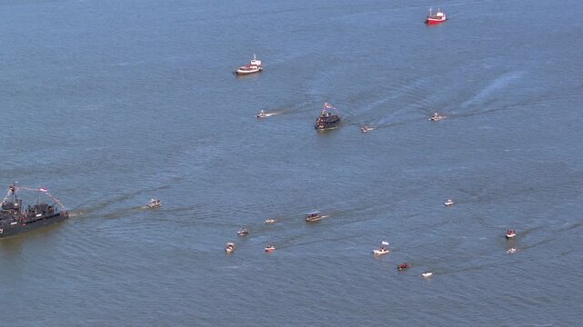 Paraguayan naval vessels and numerous support boats navigate the Paran&aacute; River in an organized maritime formation.