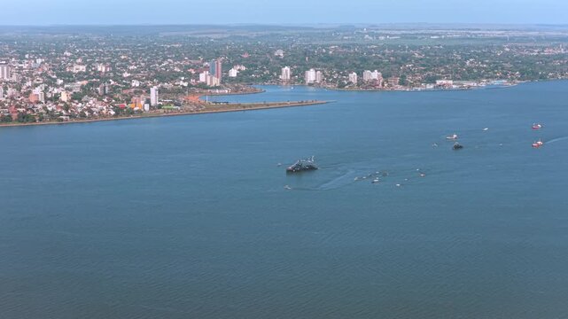 Wide aerial view of Paraguayan naval vessels and escort boats navigating together across the Paran&aacute; River.